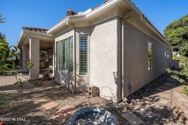 view of home's exterior with ceiling fan and a patio area