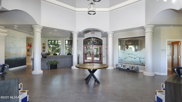 entryway with decorative columns, a high ceiling, and french doors