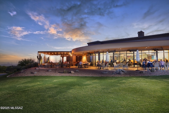 back house at dusk with a yard