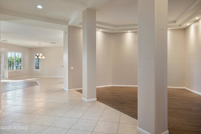 unfurnished room with an inviting chandelier and light tile patterned floors