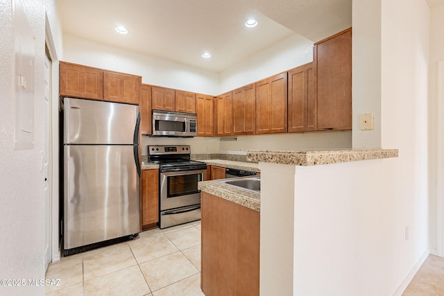 kitchen featuring light tile patterned flooring, stainless steel appliances, kitchen peninsula, and sink