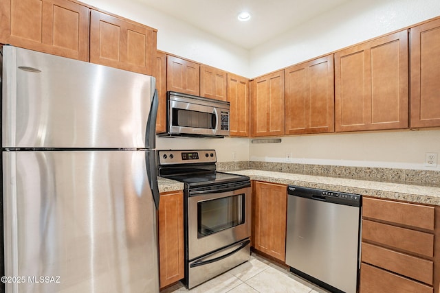 kitchen with stainless steel appliances and light tile patterned flooring