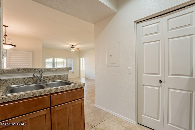 kitchen with sink, light tile patterned floors, ceiling fan, electric panel, and decorative light fixtures