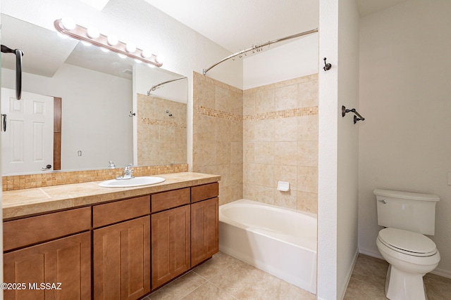 full bathroom with tile patterned flooring, tiled shower / bath, vanity, and toilet