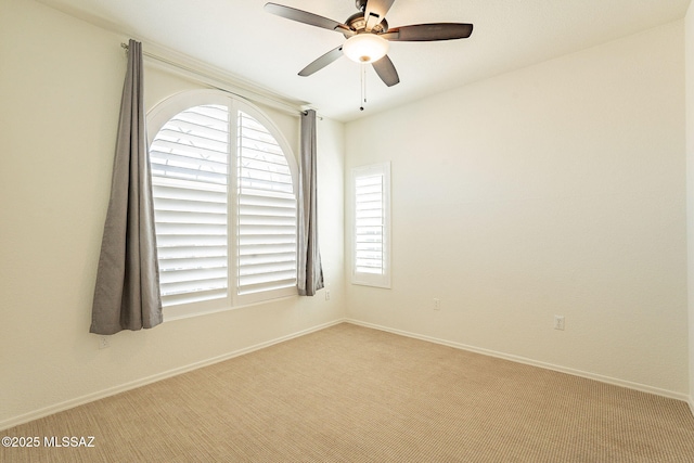 empty room with light carpet, ceiling fan, and a healthy amount of sunlight