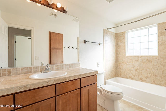 full bathroom featuring tile patterned floors, vanity, toilet, and tiled shower / bath combo