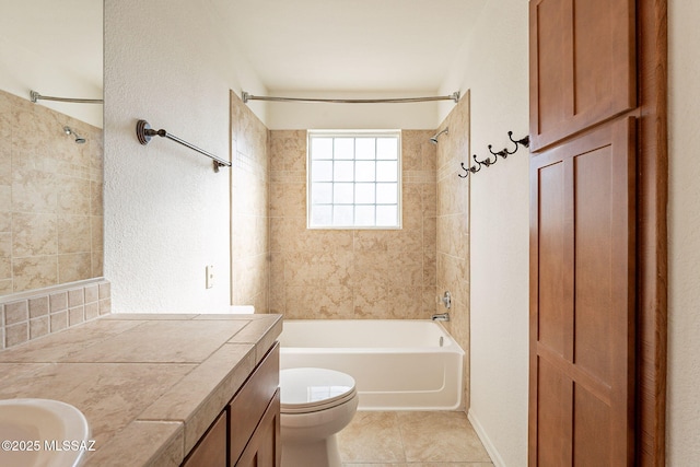 bathroom featuring tile patterned flooring, tiled shower / bath, and toilet