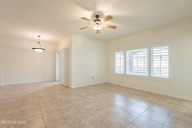 tiled spare room with ceiling fan