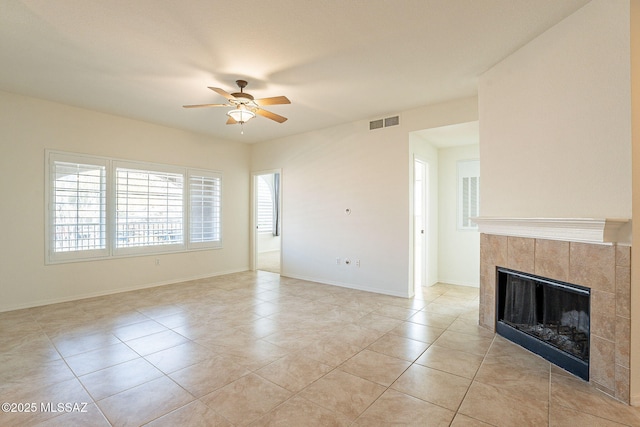 unfurnished living room featuring light tile patterned flooring, ceiling fan, and a fireplace