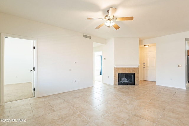 unfurnished living room featuring light tile patterned flooring, ceiling fan, and a tiled fireplace