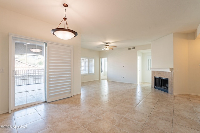 unfurnished living room with light tile patterned flooring, ceiling fan, and a fireplace