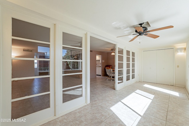 spare room featuring french doors and light tile patterned flooring