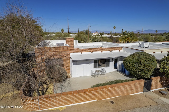 view of front of home with a patio and fence