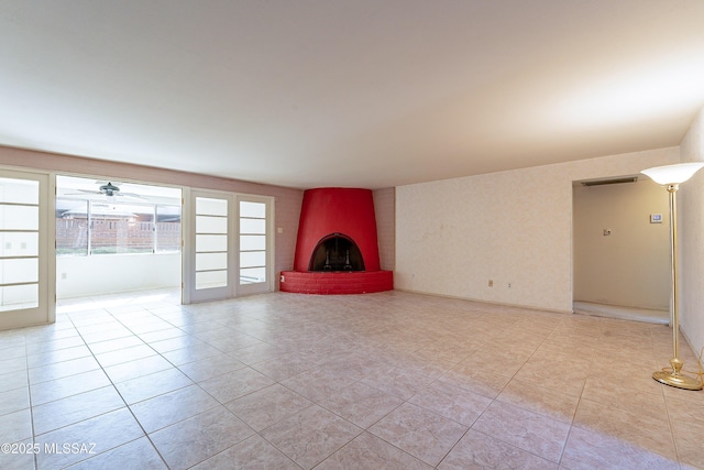 unfurnished living room with a brick fireplace and light tile patterned floors