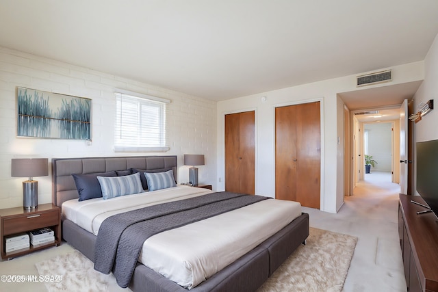 bedroom with visible vents and multiple closets