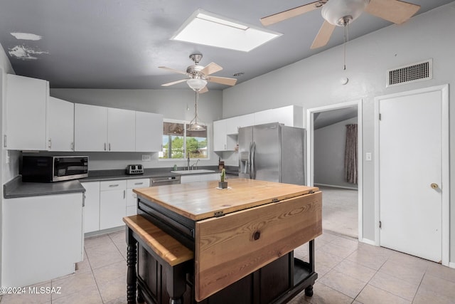 kitchen featuring sink, light tile patterned floors, white cabinets, and appliances with stainless steel finishes