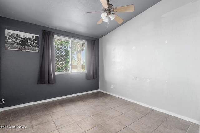 empty room with ceiling fan and tile patterned flooring