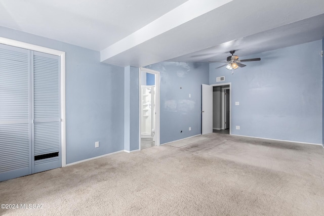 spare room featuring light colored carpet and ceiling fan