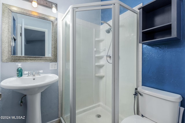 bathroom featuring toilet and a shower with door