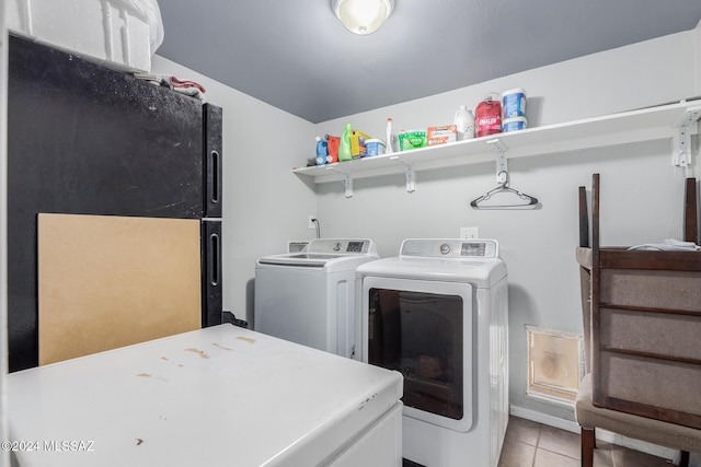 washroom with light tile patterned flooring and washer and dryer