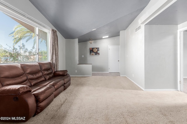 carpeted living room featuring lofted ceiling