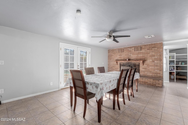 dining space with a fireplace, french doors, ceiling fan, and light tile patterned flooring