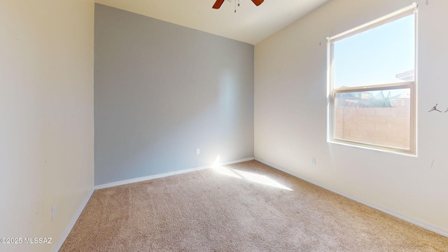 carpeted spare room featuring ceiling fan