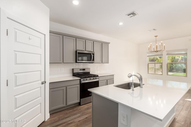 kitchen featuring visible vents, appliances with stainless steel finishes, gray cabinets, and a sink