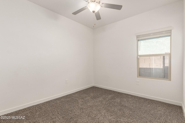 empty room with baseboards, dark carpet, and ceiling fan