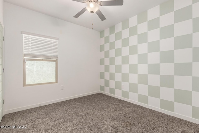 carpeted empty room featuring ceiling fan and baseboards