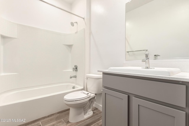 bathroom featuring toilet, wood tiled floor, vanity, and bathing tub / shower combination