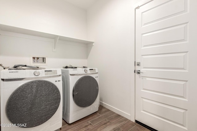 laundry area with baseboards, laundry area, washing machine and clothes dryer, and wood tiled floor