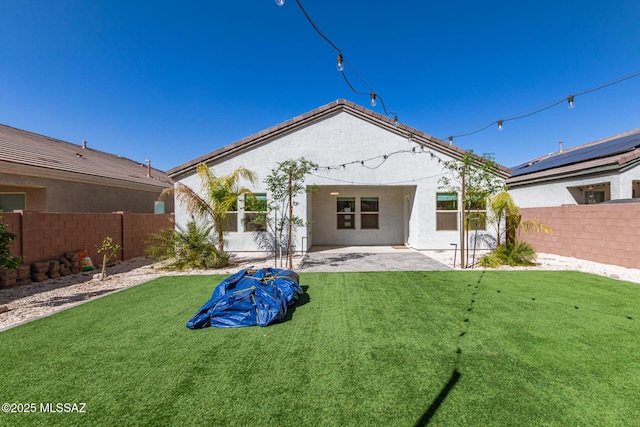 back of property with a lawn, a patio area, a fenced backyard, and stucco siding