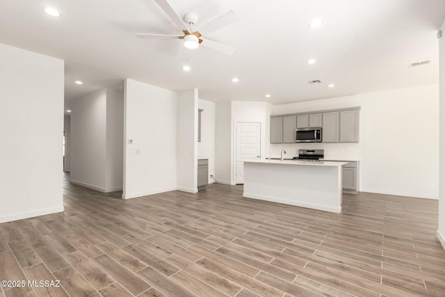 kitchen featuring visible vents, appliances with stainless steel finishes, open floor plan, and gray cabinetry