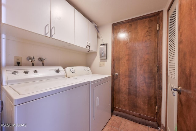 washroom with cabinets, washer and clothes dryer, and light tile patterned floors