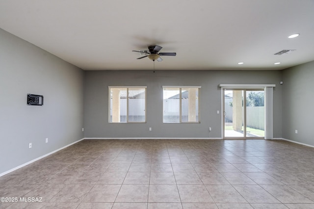 tiled spare room featuring ceiling fan