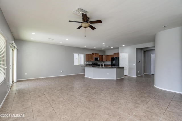 unfurnished living room with sink, light tile patterned floors, and ceiling fan