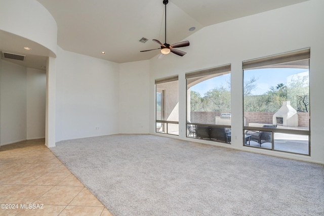 unfurnished living room with ceiling fan, light colored carpet, and high vaulted ceiling