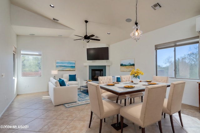 dining room with light tile patterned flooring, ceiling fan, and vaulted ceiling