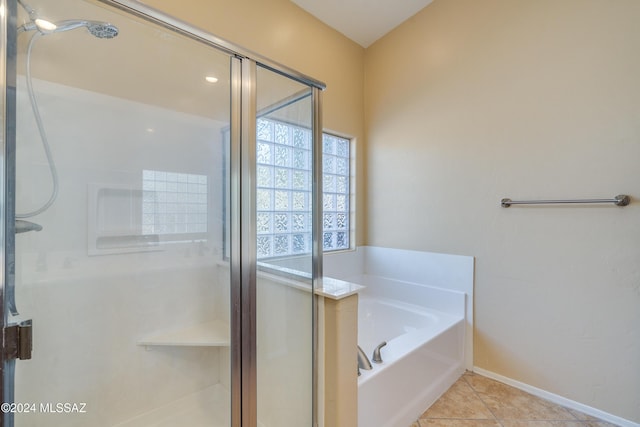 bathroom with tile patterned floors and shower with separate bathtub