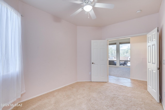 empty room featuring light carpet and ceiling fan