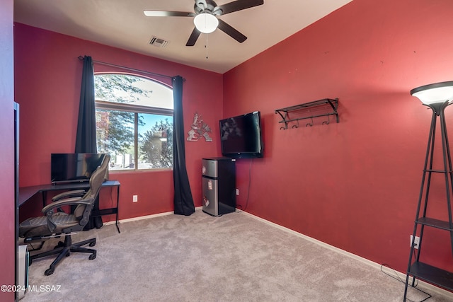 carpeted office space featuring ceiling fan