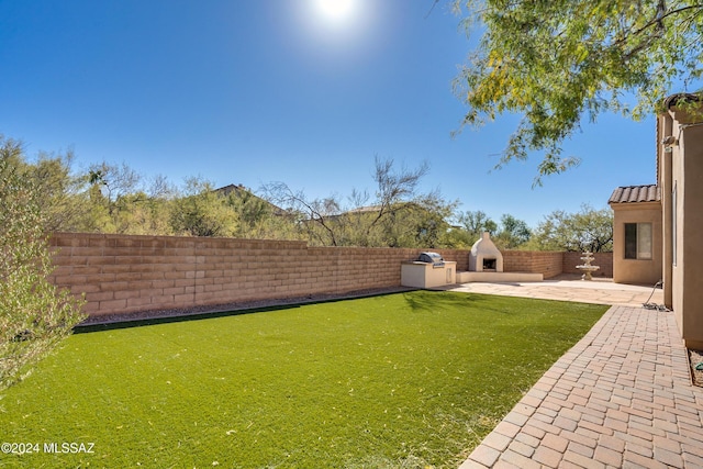 view of yard featuring a fireplace and a patio