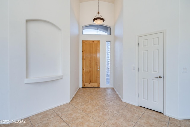 tiled entrance foyer featuring a towering ceiling