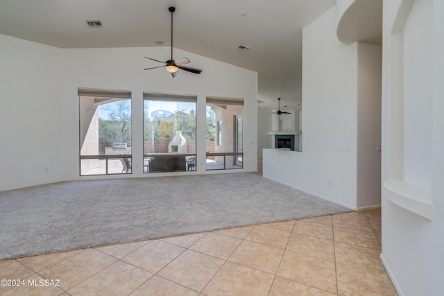 unfurnished living room with ceiling fan, high vaulted ceiling, and light carpet