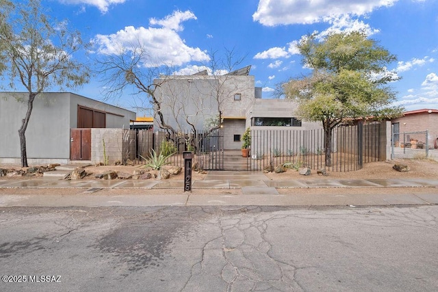 view of front of property with a fenced front yard, a gate, and stucco siding