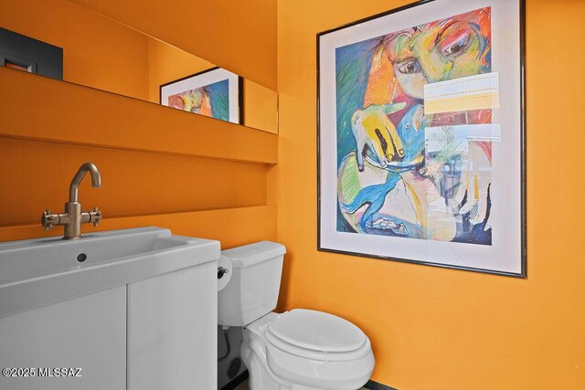 1125 N 13th Ave, Tucson, AZ 85705 - bathroom featuring toilet, vanity, and baseboards