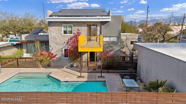 1125 N 13th Ave, Tucson, AZ 85705 - back of property featuring solar panels, fence, a patio area, and a fenced in pool