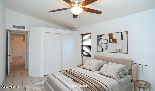 tiled bedroom featuring vaulted ceiling, a closet, and ceiling fan