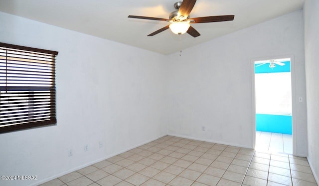 tiled spare room featuring ceiling fan